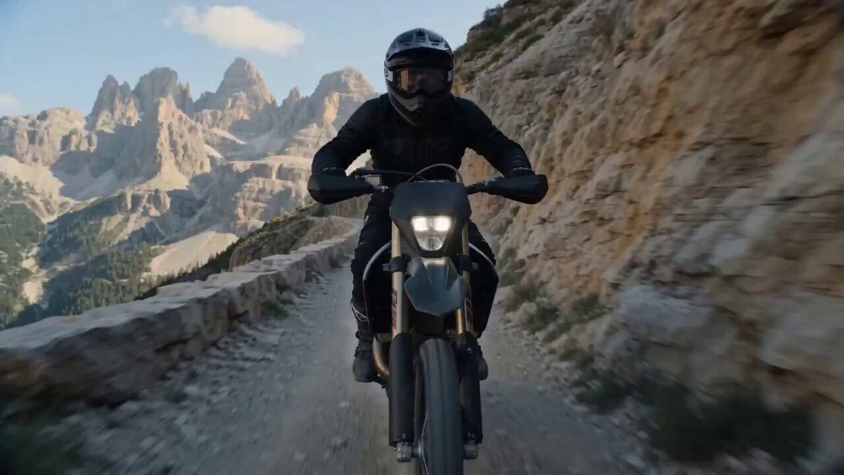 崖沿いのトレイルを疾走するシネマティックなバイクアクション
